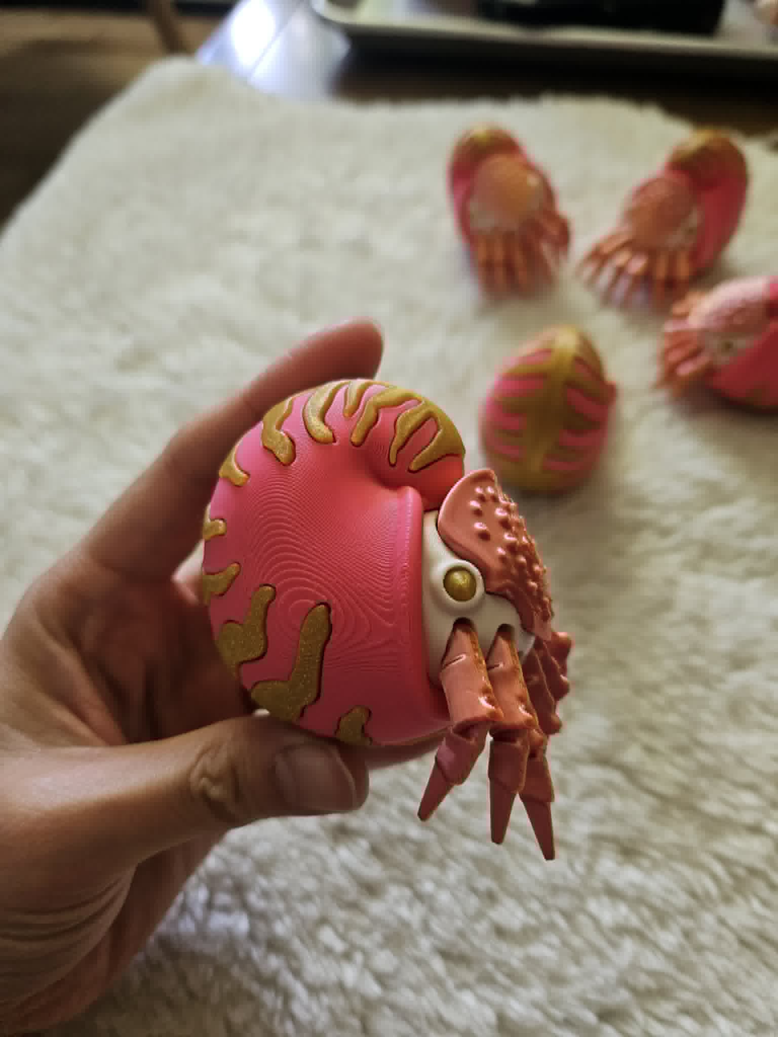 Articulated pink and gold ammonite creature