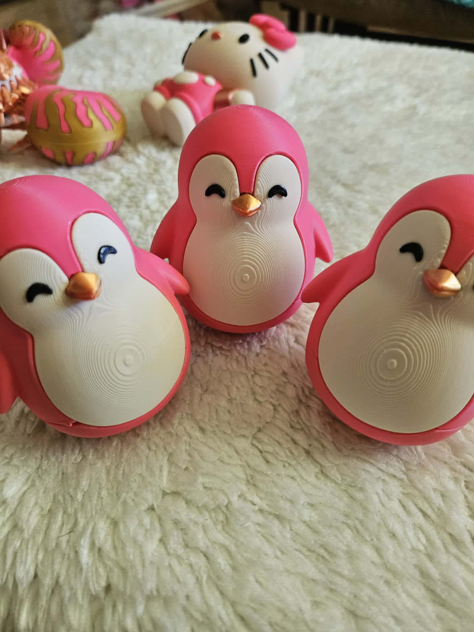 Trio of pink and white 3D printed penguins